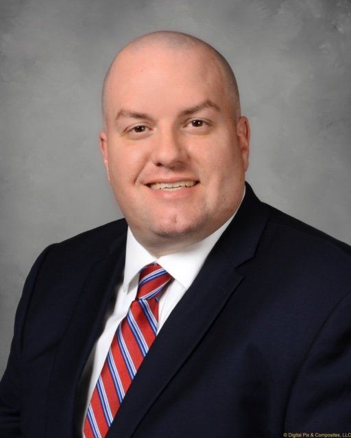A man in a suit and tie is smiling for the camera A man in a suit and tie is smiling for the camera