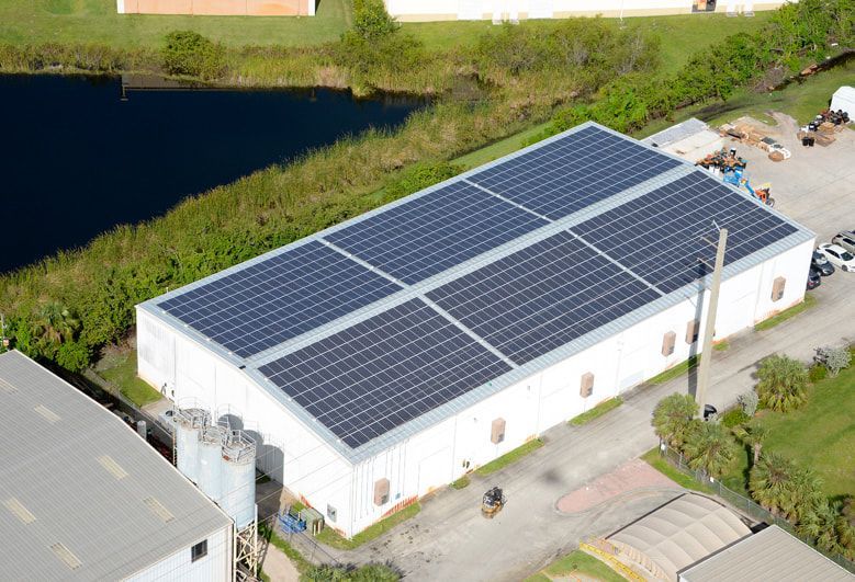 An aerial view of a large building with solar panels on the roof.