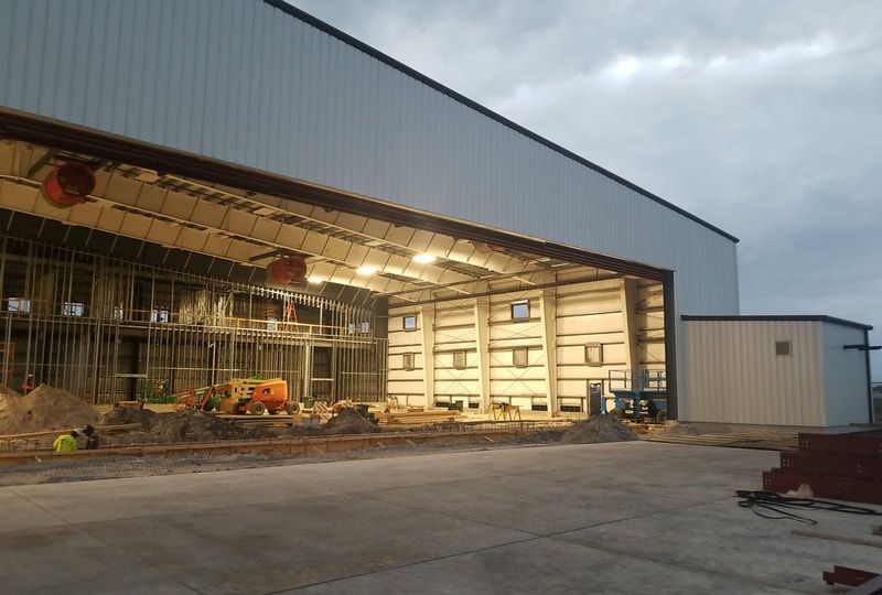 A large building under construction with a large sliding door.