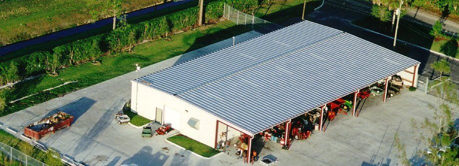 An aerial view of a large white building with a metal roof