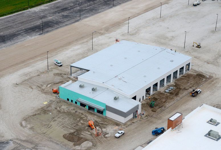 An aerial view of a building under construction in a dirt field.