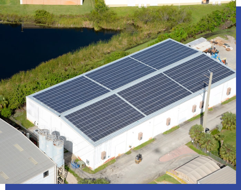 An aerial view of a building with solar panels on the roof.