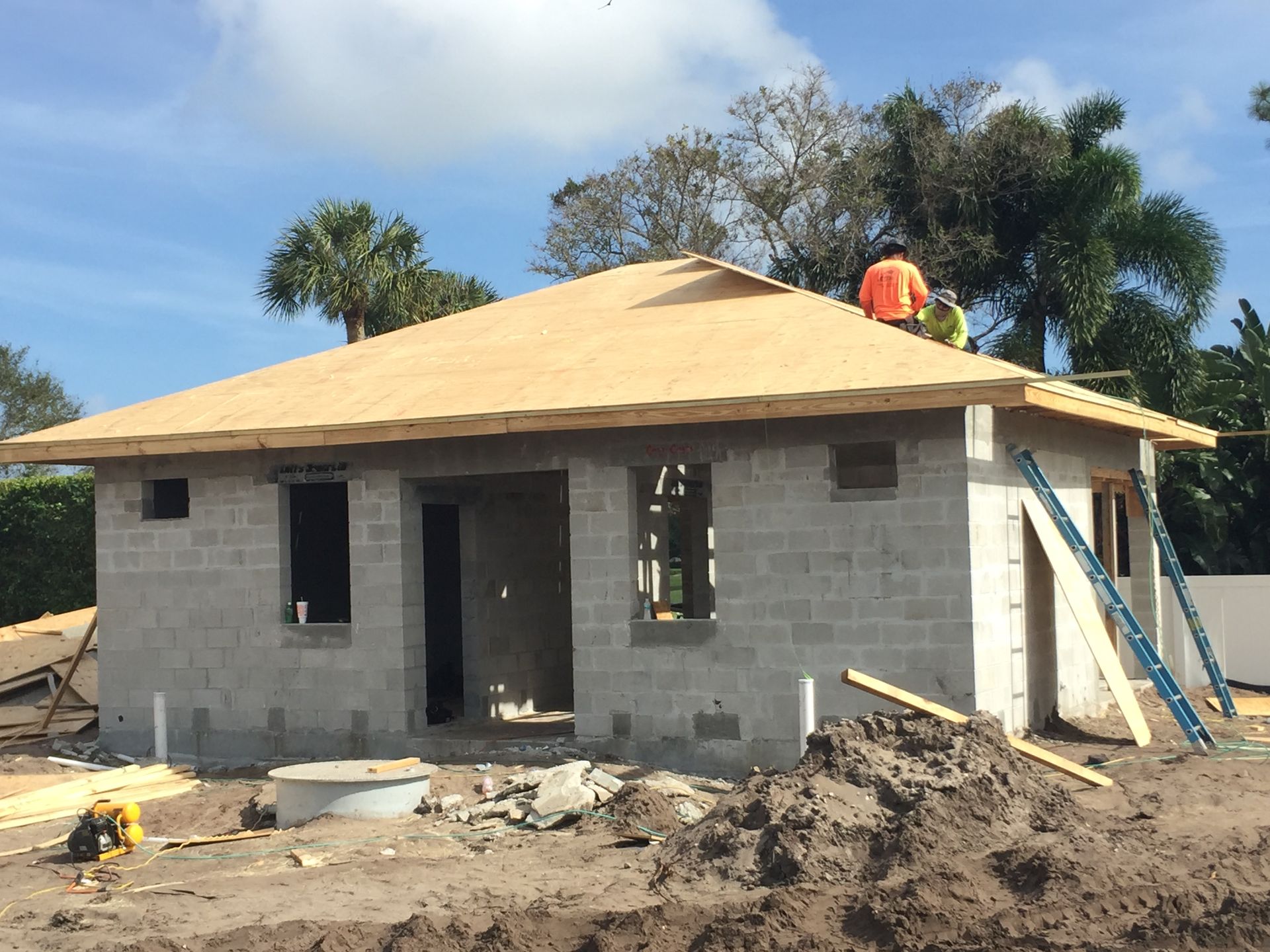 A man is working on the roof of a brick house