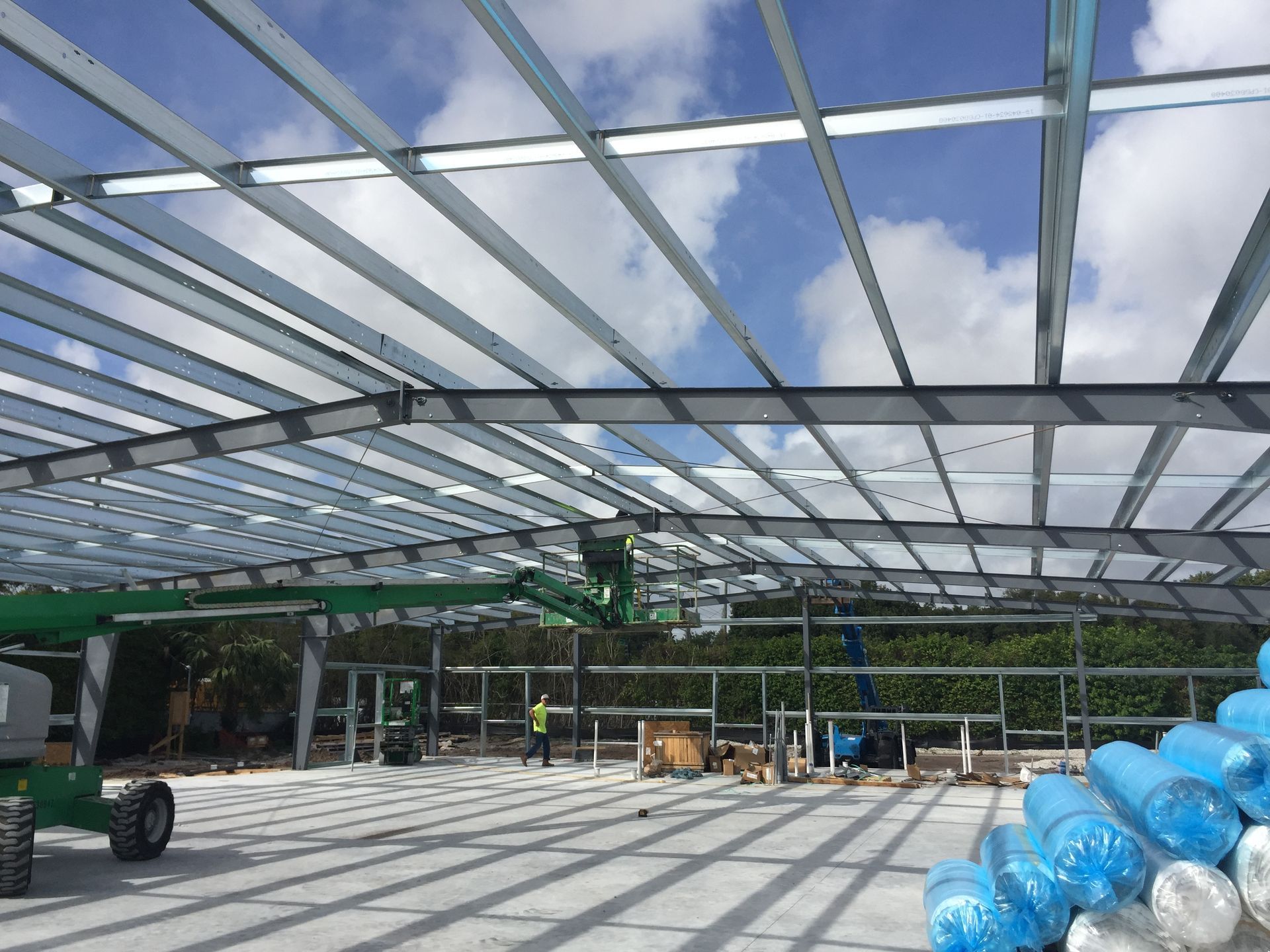 A large metal structure is being built on a sunny day.