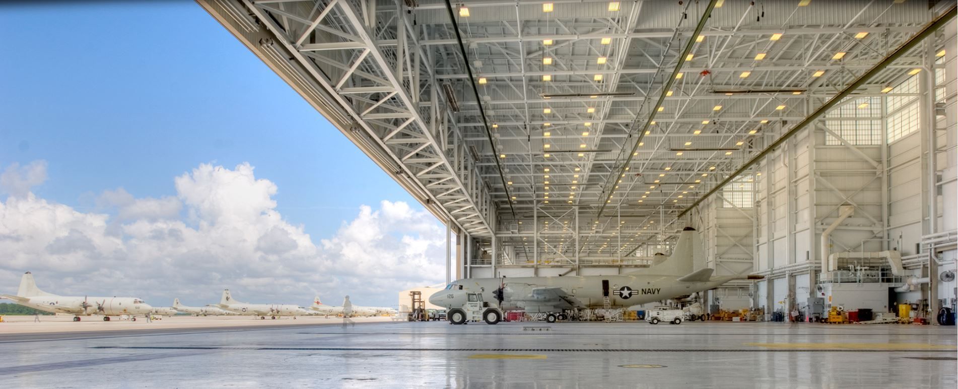 A large empty airplane hangar with the roof open.