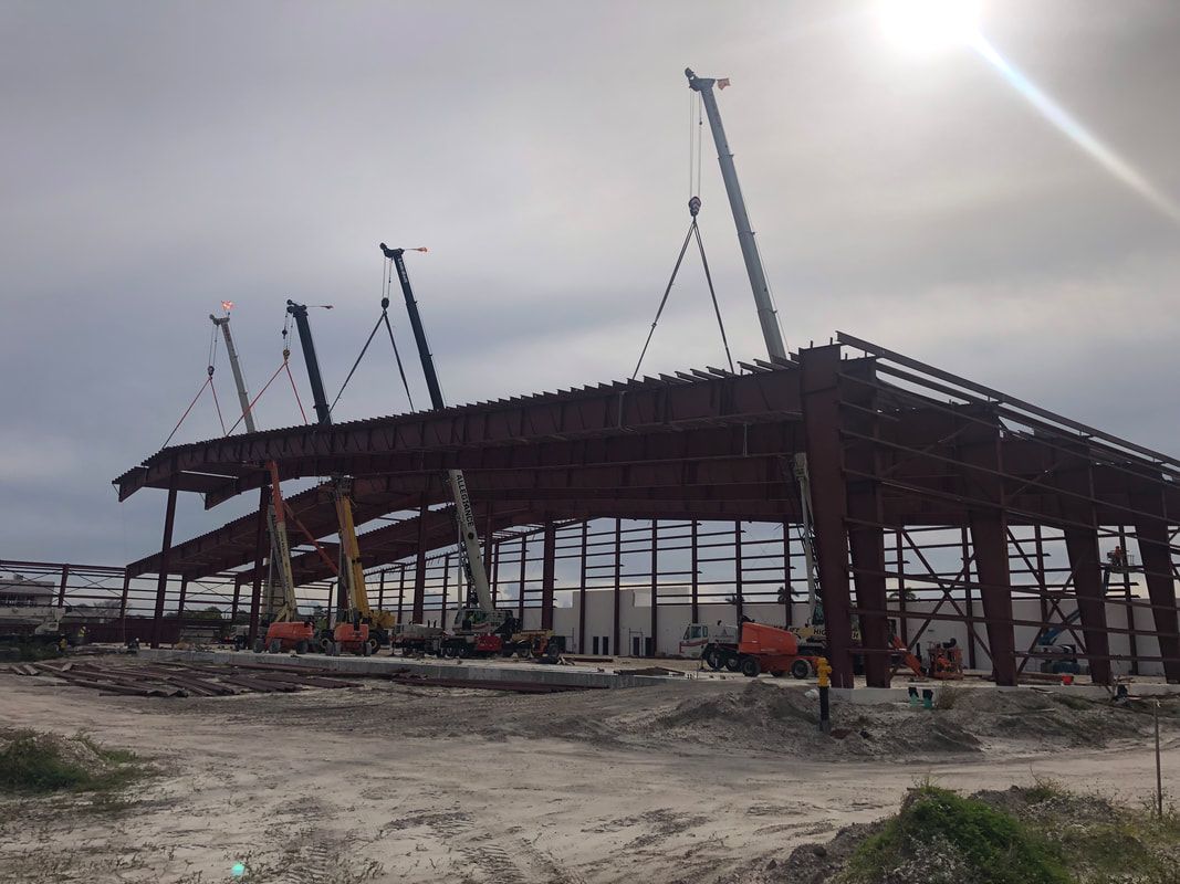 A large metal structure is being built on a cloudy day.