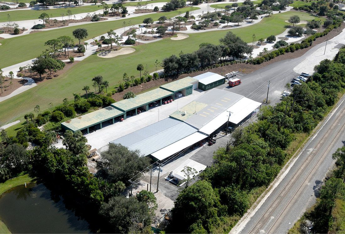 An aerial view of a building surrounded by trees and a golf course.
