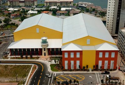 An aerial view of a yellow and red building with a white roof