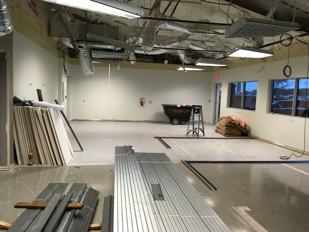 A large empty room with a lot of pieces of metal on the floor.