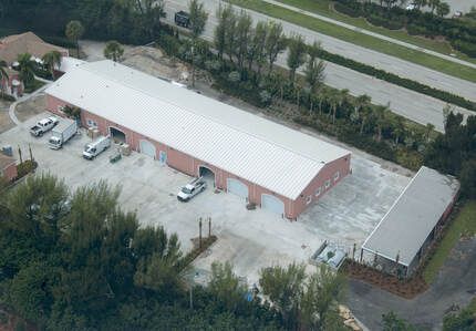 An aerial view of a large building with cars parked in front of it.