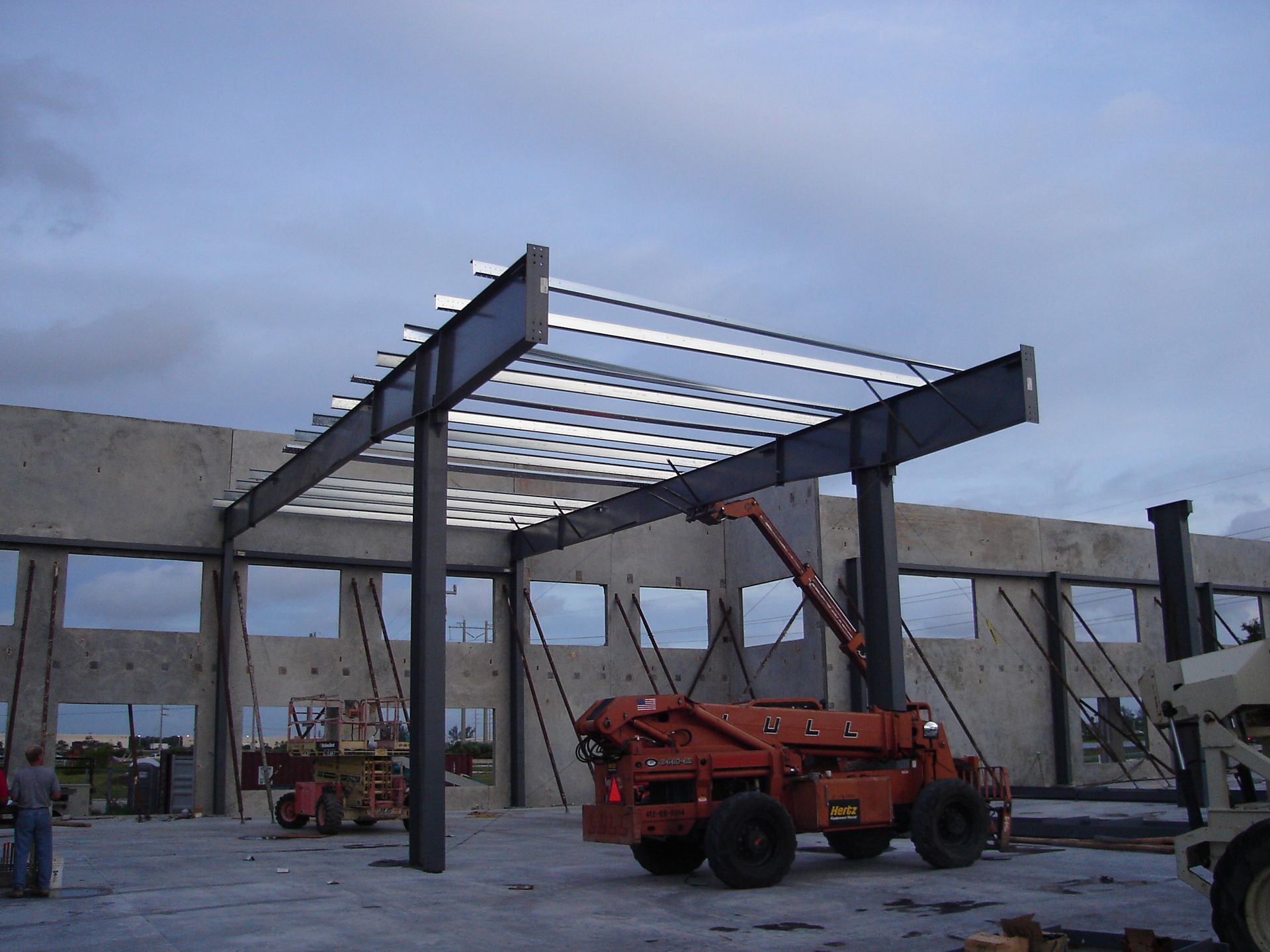 A large concrete building under construction with a crane in the foreground