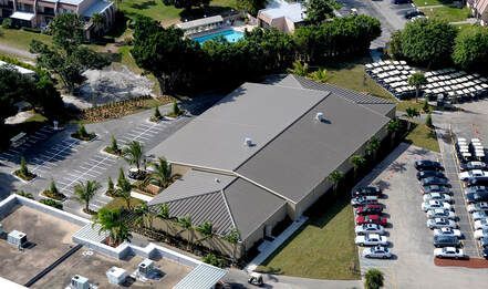 An aerial view of a building with a lot of cars parked in front of it