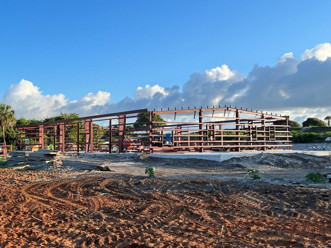 A building is being built in the middle of a dirt field.