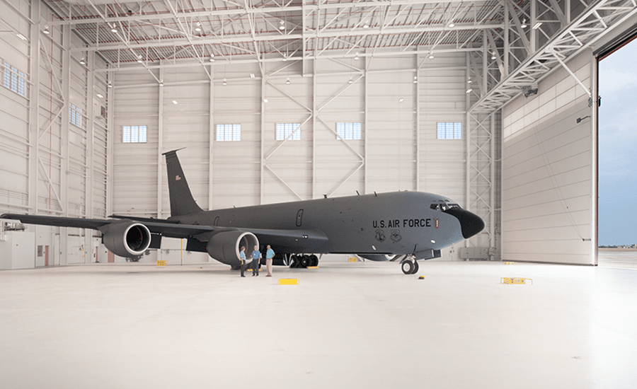 A large military plane is parked in a hangar.
