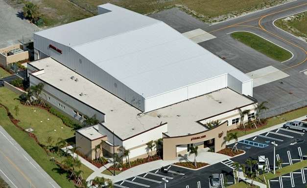 An aerial view of a large building with a white roof