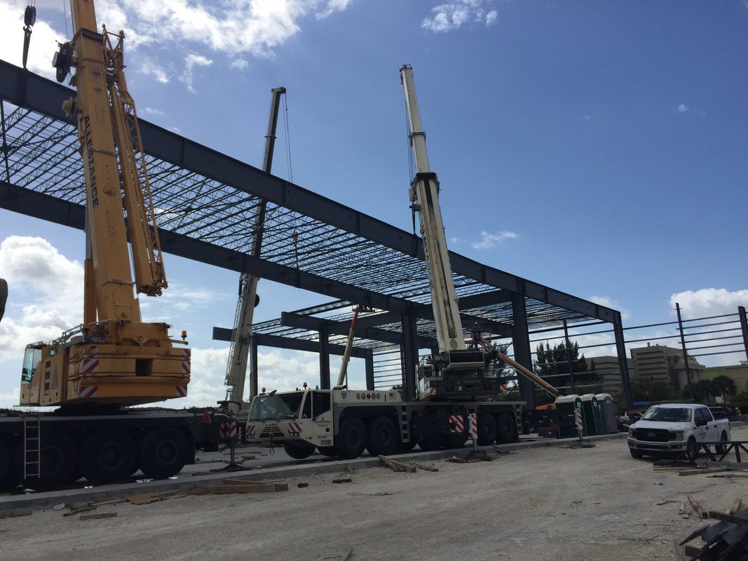 A construction site with a lot of trucks and cranes.