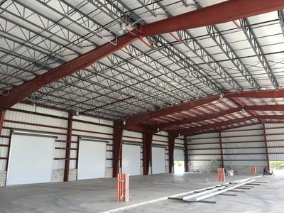 The inside of a large warehouse with a metal roof.