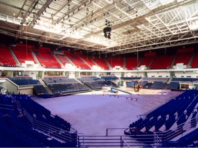 An empty stadium with blue seats and red seats
