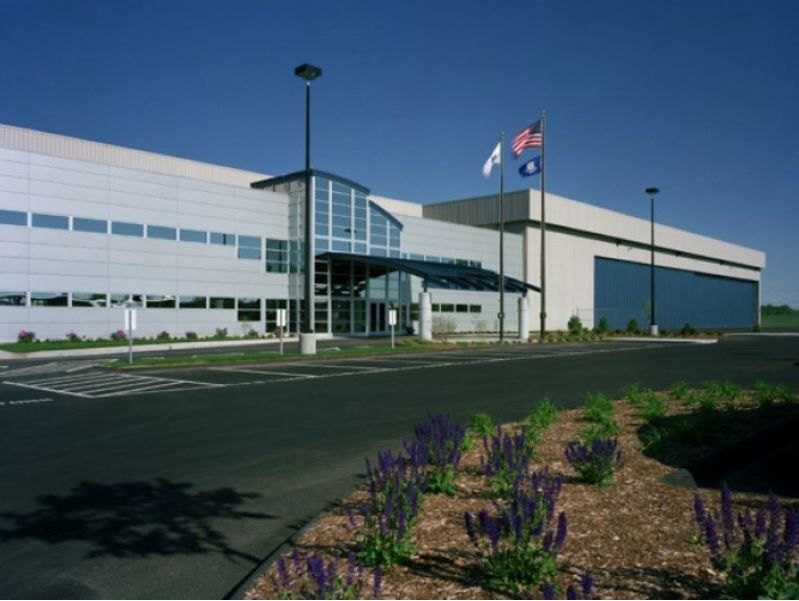 A large white building with purple flowers in front of it