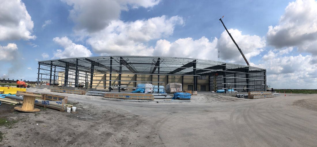 A large building under construction with a crane in the foreground.