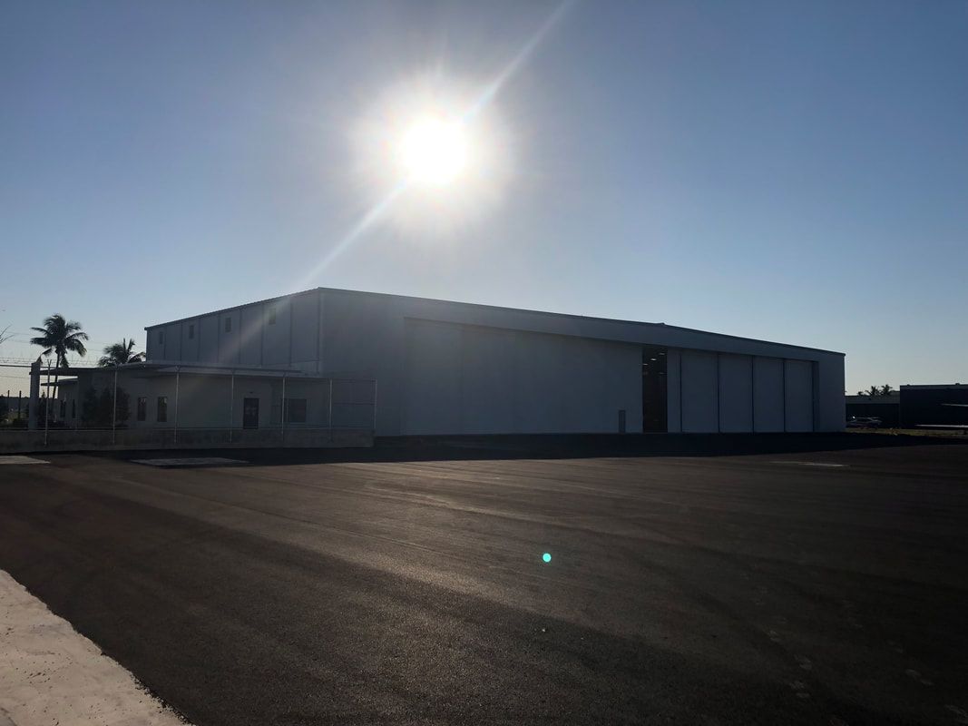 A large white building with the sun shining on it