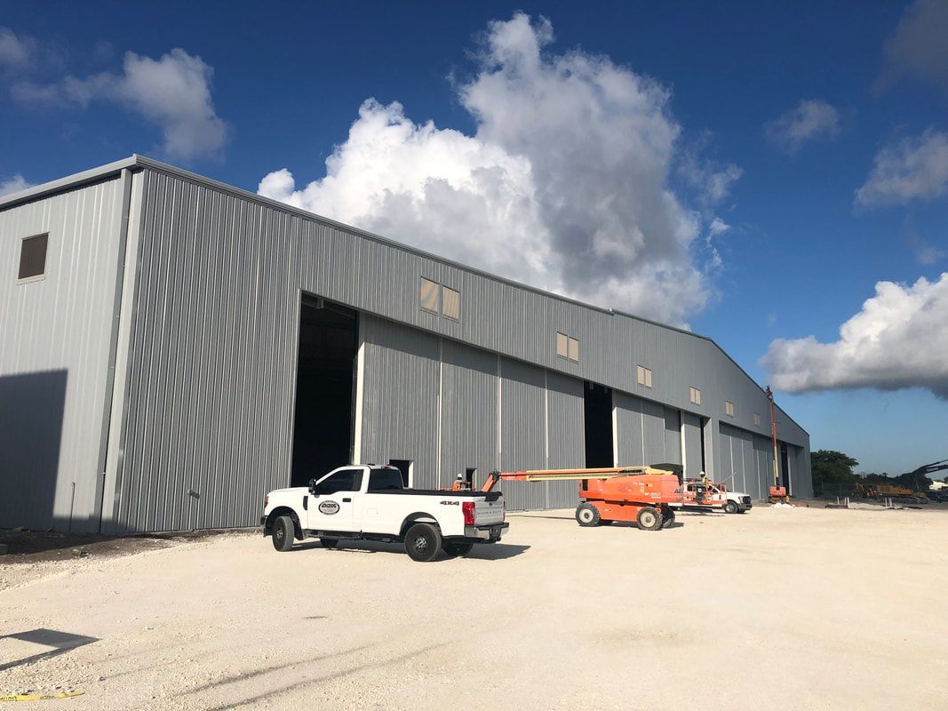 A white truck is parked in front of a large building.