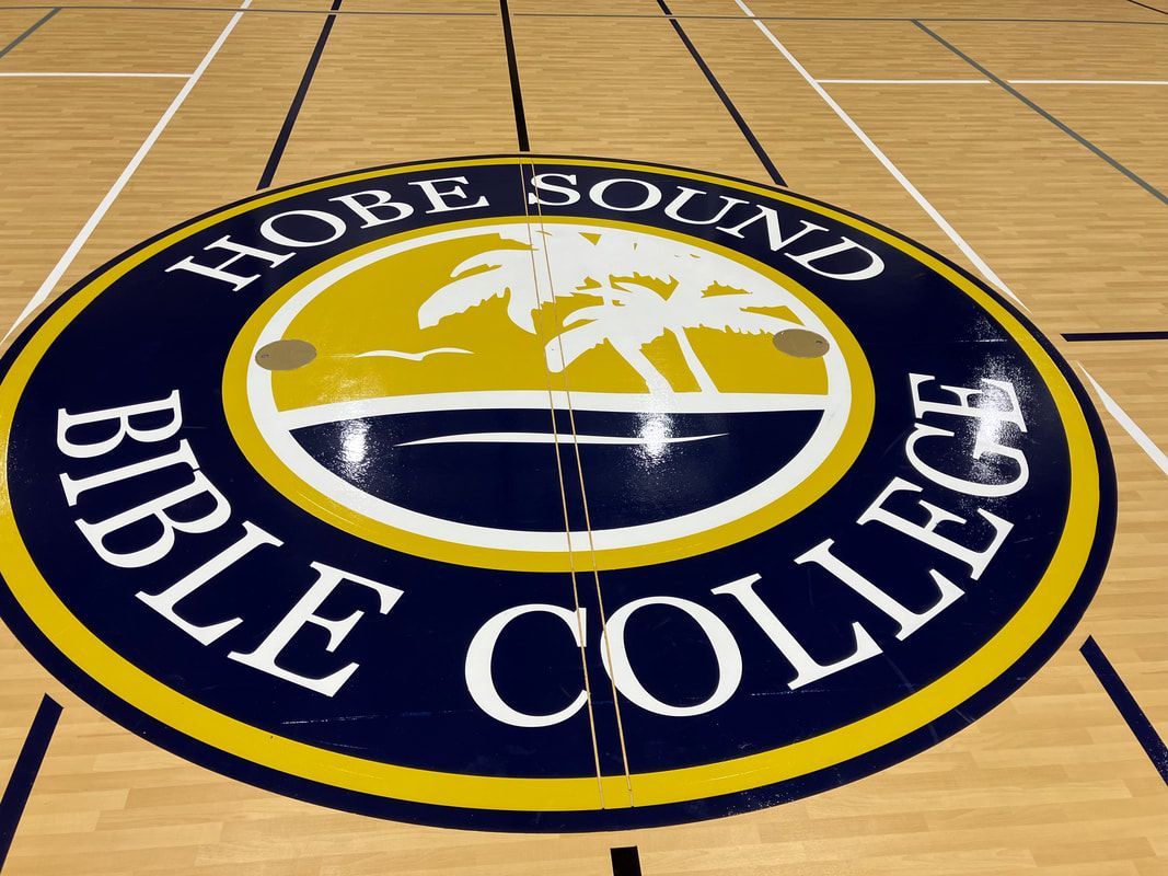 A logo for hobe sound bible college on a basketball court
