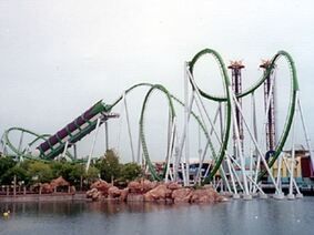 A roller coaster is sitting next to a body of water.