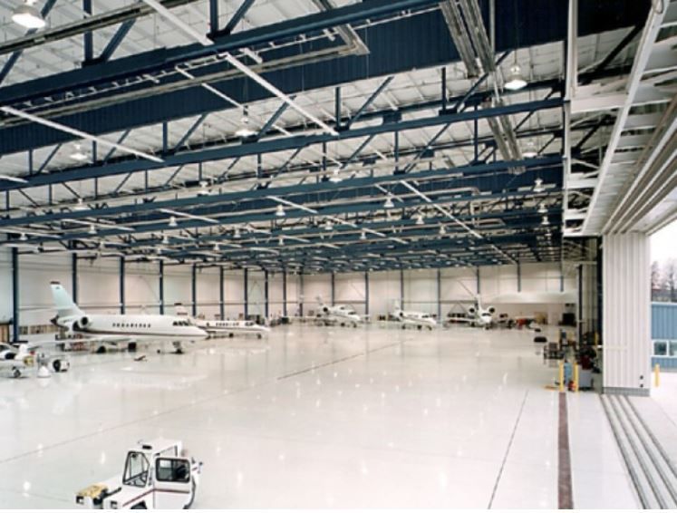 A large hangar with a few planes inside of it