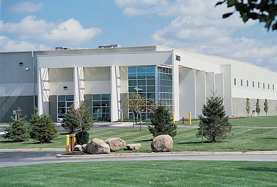 A large building with a car parked in front of it.