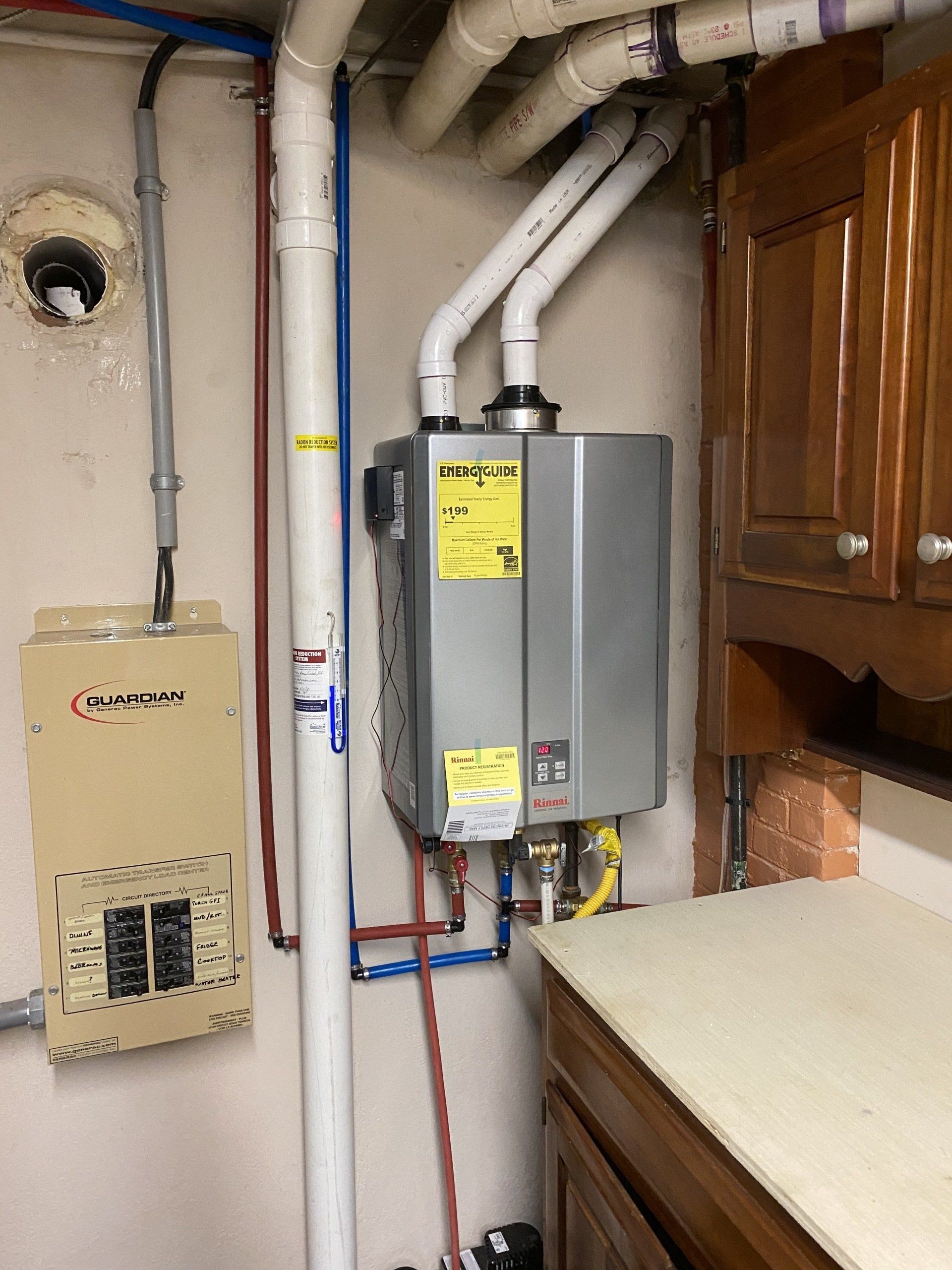 A water heater is installed in a kitchen next to a cabinet.