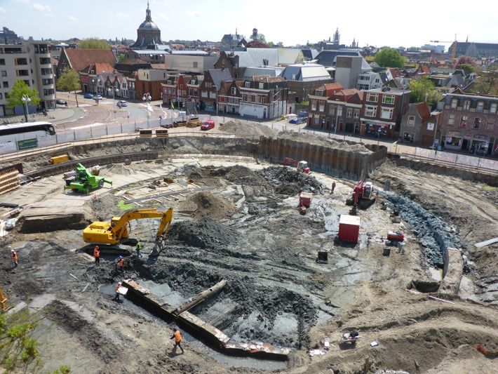 An aerial view of a construction site with buildings in the background