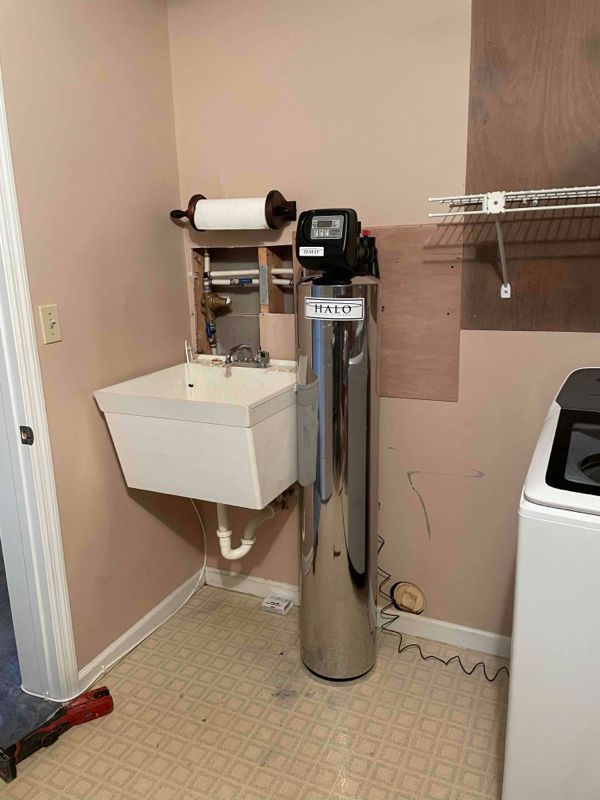 A laundry room with a sink and a Halo water filter.