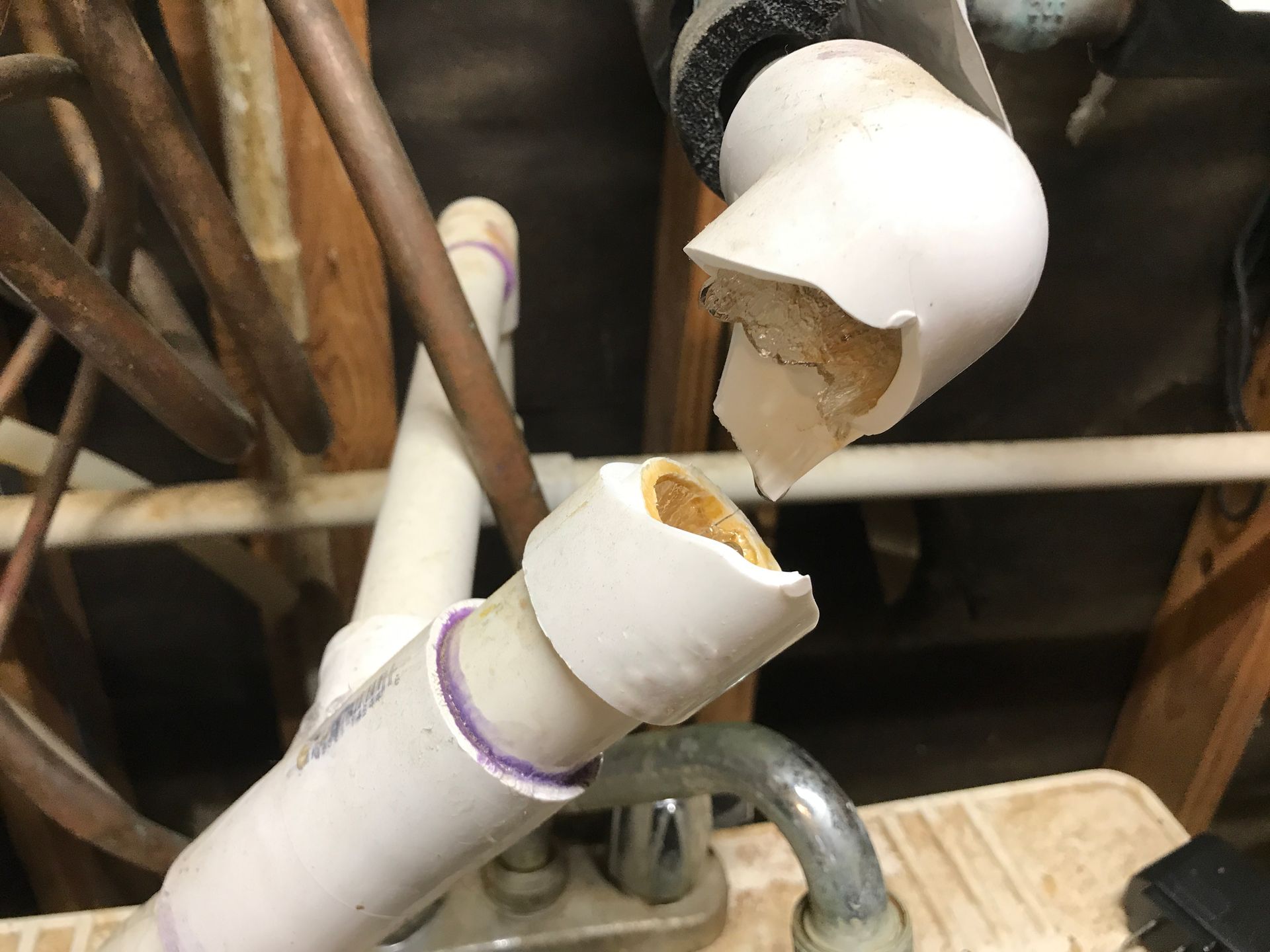 Broken white PVC plumbing pipe with exposed interior, possibly water damage.