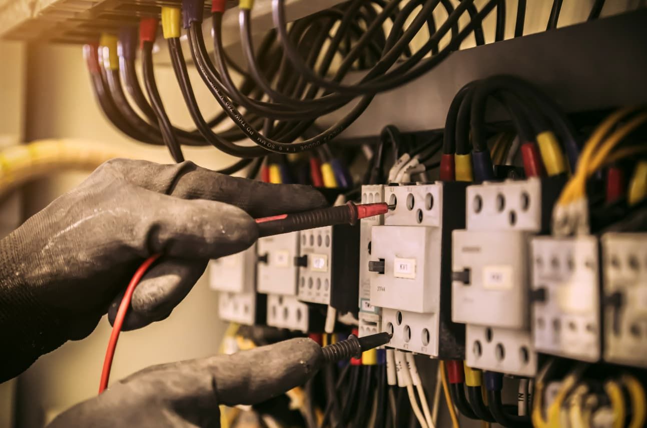 An Electrician Is Working On An Electrical Panel — A.G Auto Electrical & Air-Conditioning In Hidden Valley, QLD