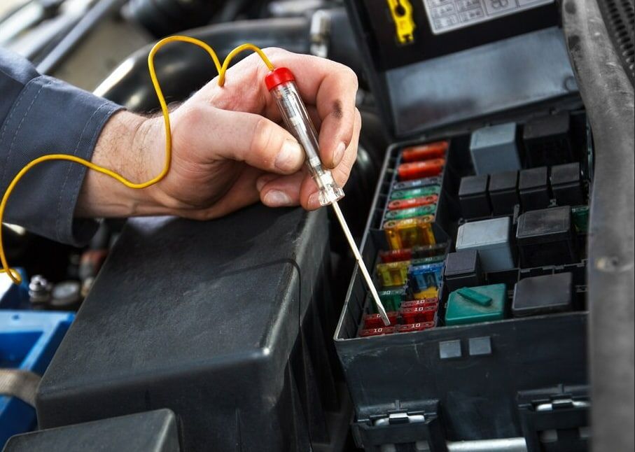 A Person Is Working On A Car With A Voltage Tester — A.G Auto Electrical & Air-Conditioning In Hidden Valley, QLD