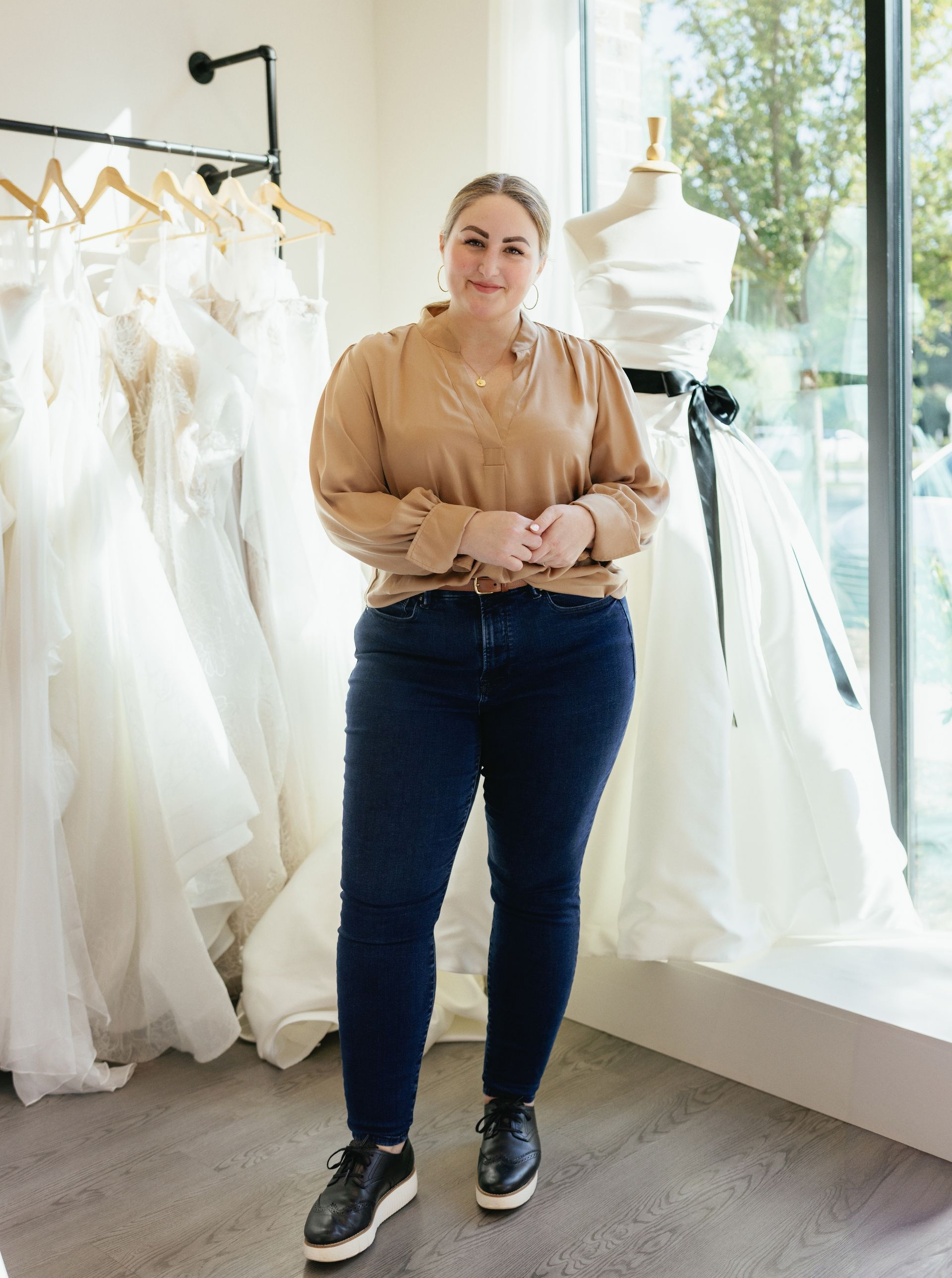 A woman is sitting on a chair in a bridal shop.