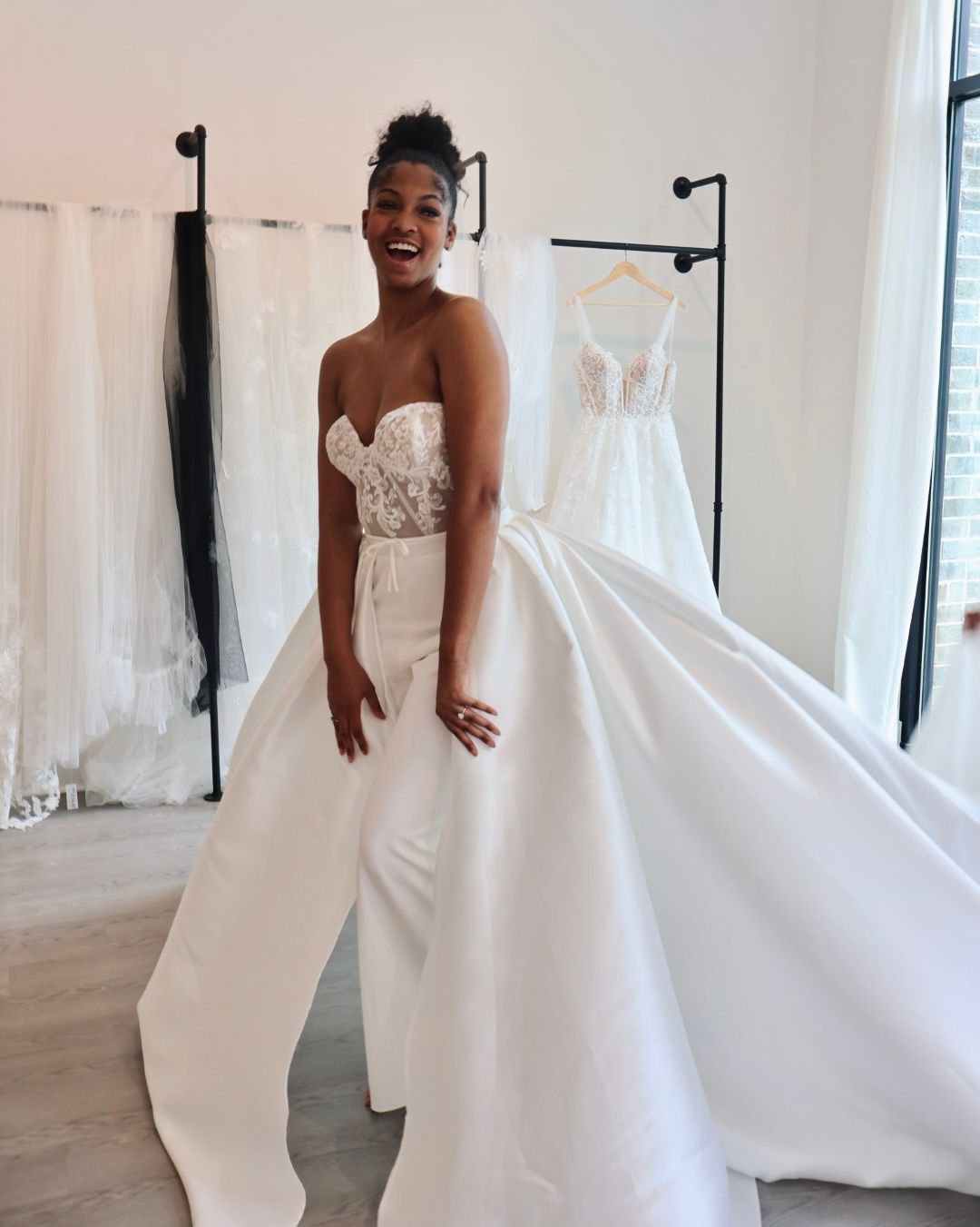 A woman is trying on a wedding dress in a bridal shop.