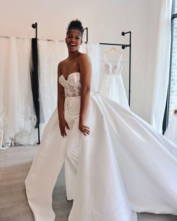 A woman is trying on a wedding dress in a bridal shop.