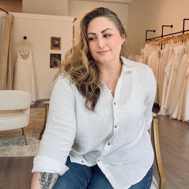 A woman is sitting on a chair in a bridal shop.