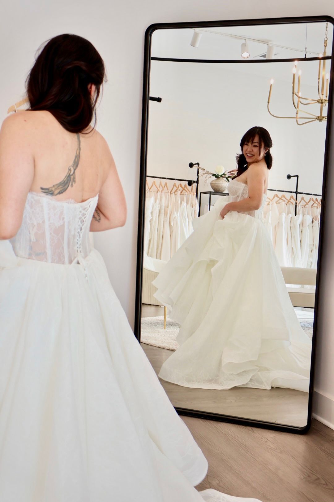 A woman is trying on a wedding dress in a bridal shop.