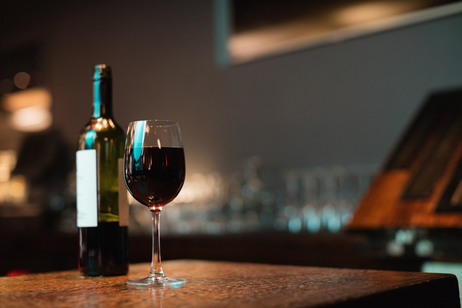 Vino tinto y copa llena en la mesa de un bar
