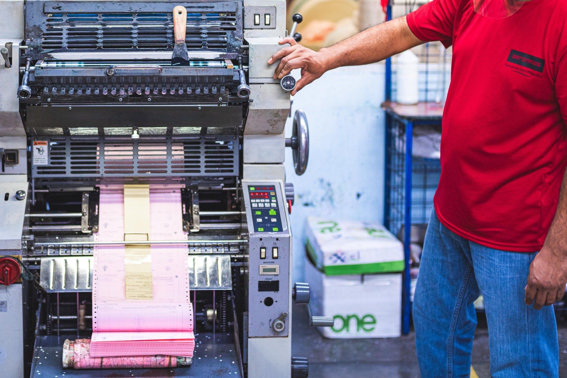 Trabajador accionando una máquina de impresión