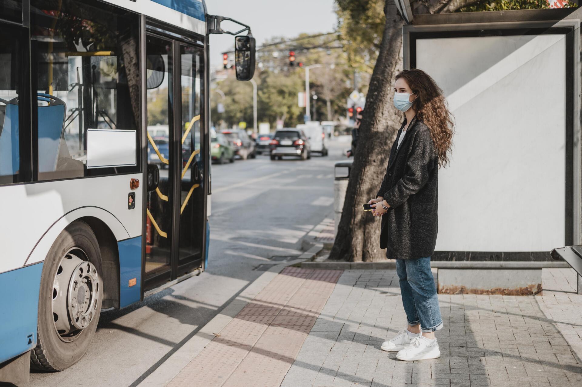 Mujer de vista lateral esperando el autobús Mujer de vista lateral esperando el autobús