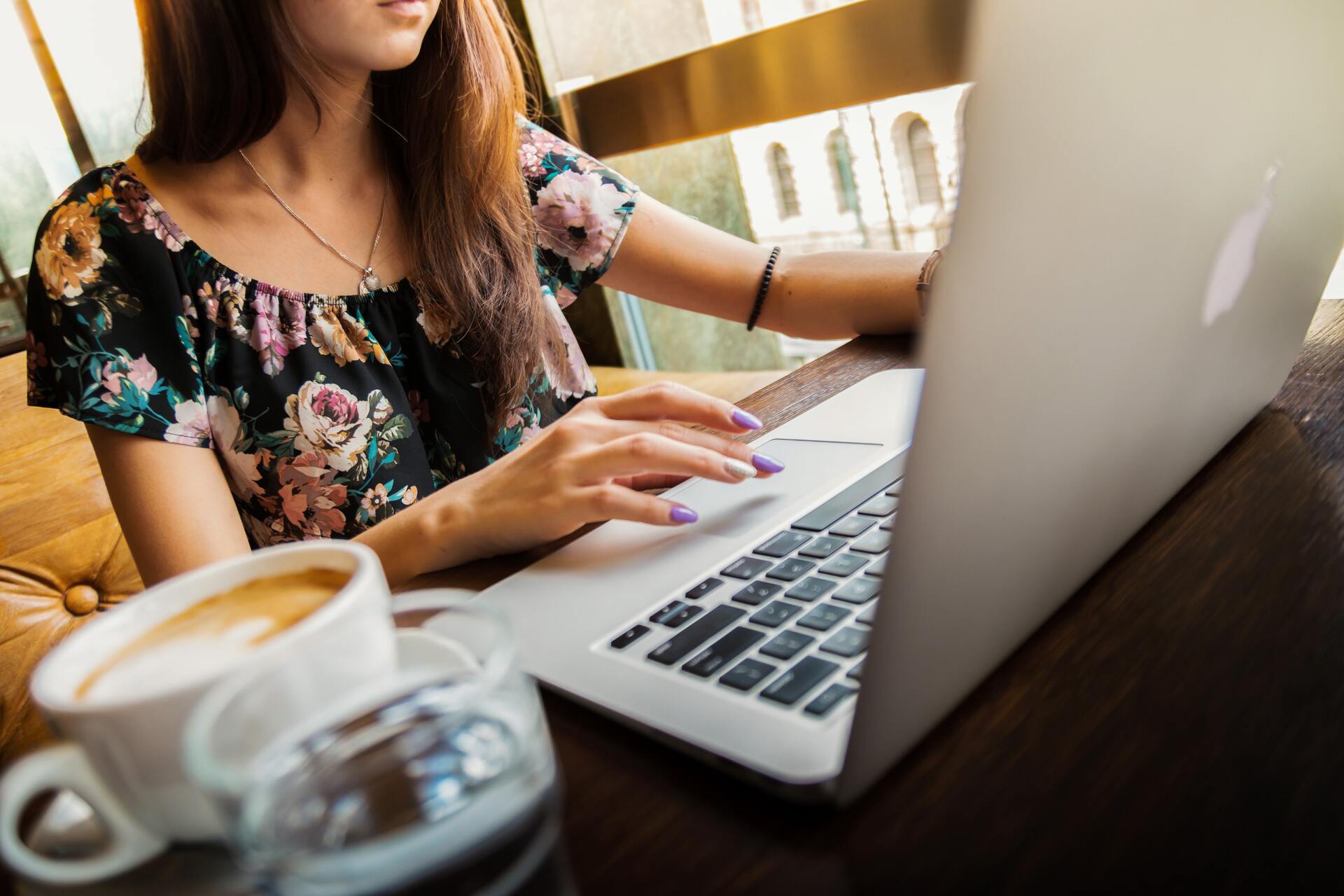 Mujer joven utilizando un computadora portátil para preparar su archivo a imprimir Mujer joven utilizando un computadora portátil para preparar su archivo a imprimir