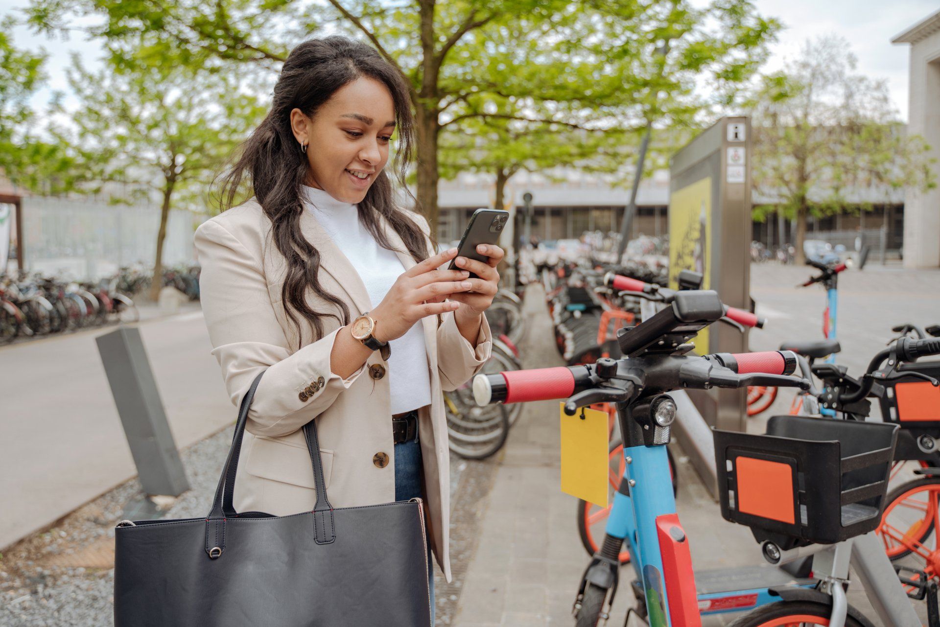 Mujer sonriente usando aplicación móvil escaneando código qr para alquilar scooter eléctrico Mujer sonriente usando aplicación móvil escaneando código qr para alquilar scooter eléctrico