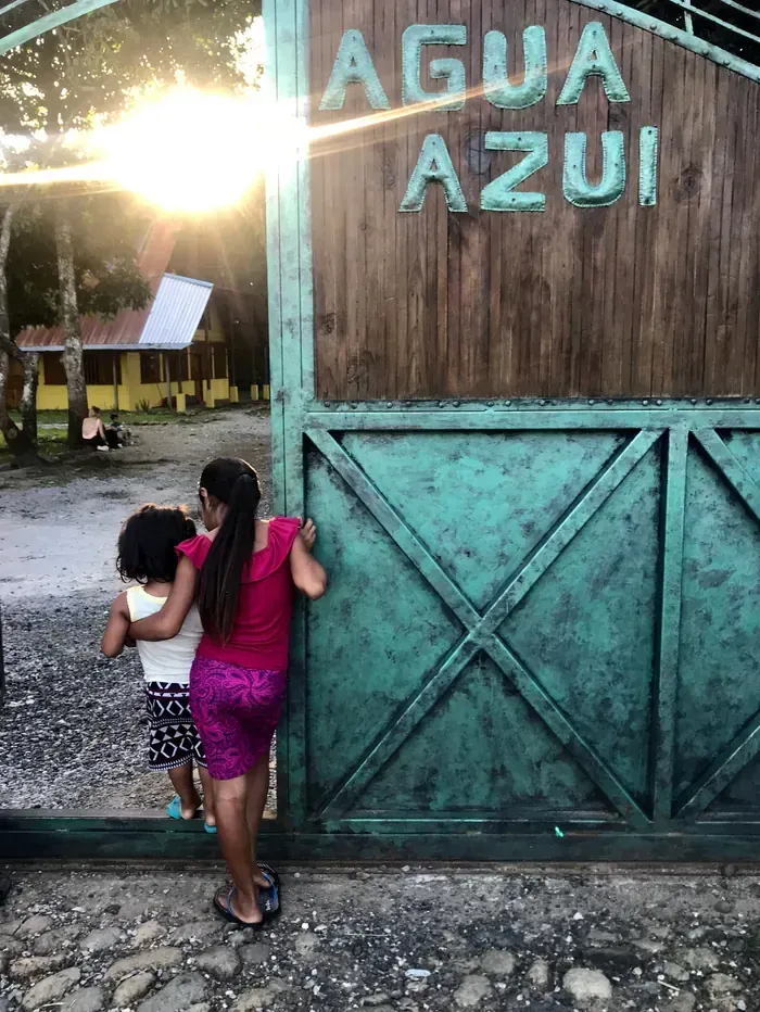 Entrance gate to Casa Agua Azul children's home with children entering the property