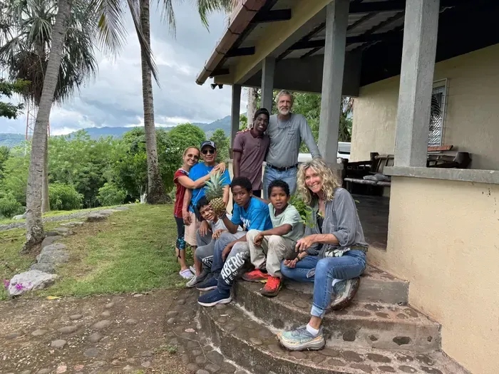 Volunteers and children posing on steps of the mission house