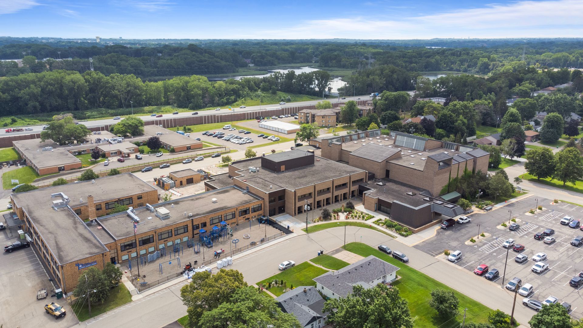 An aerial view of a large building with a lot of cars parked in front of it.
