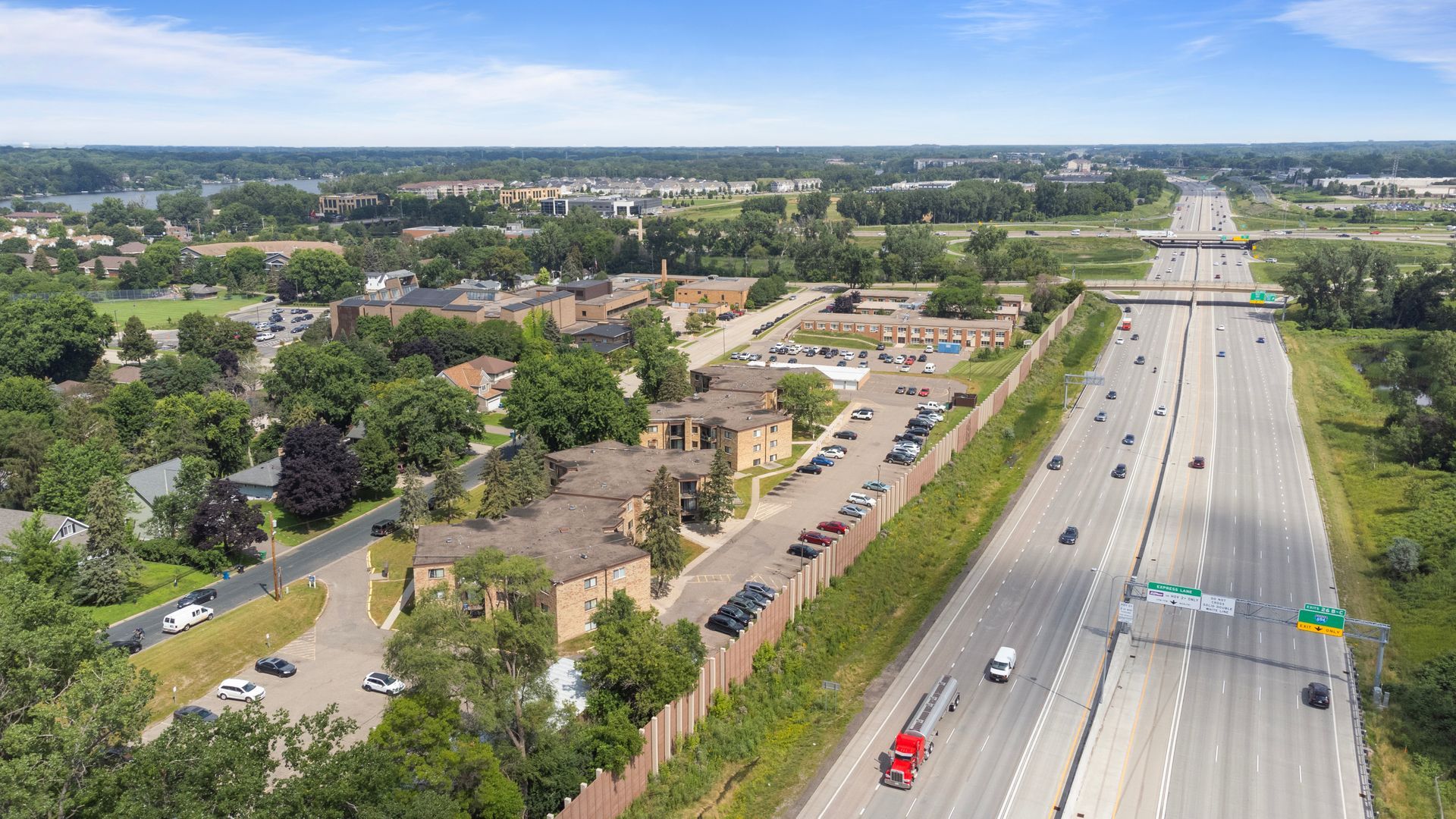 An aerial view of a highway going through a residential area.